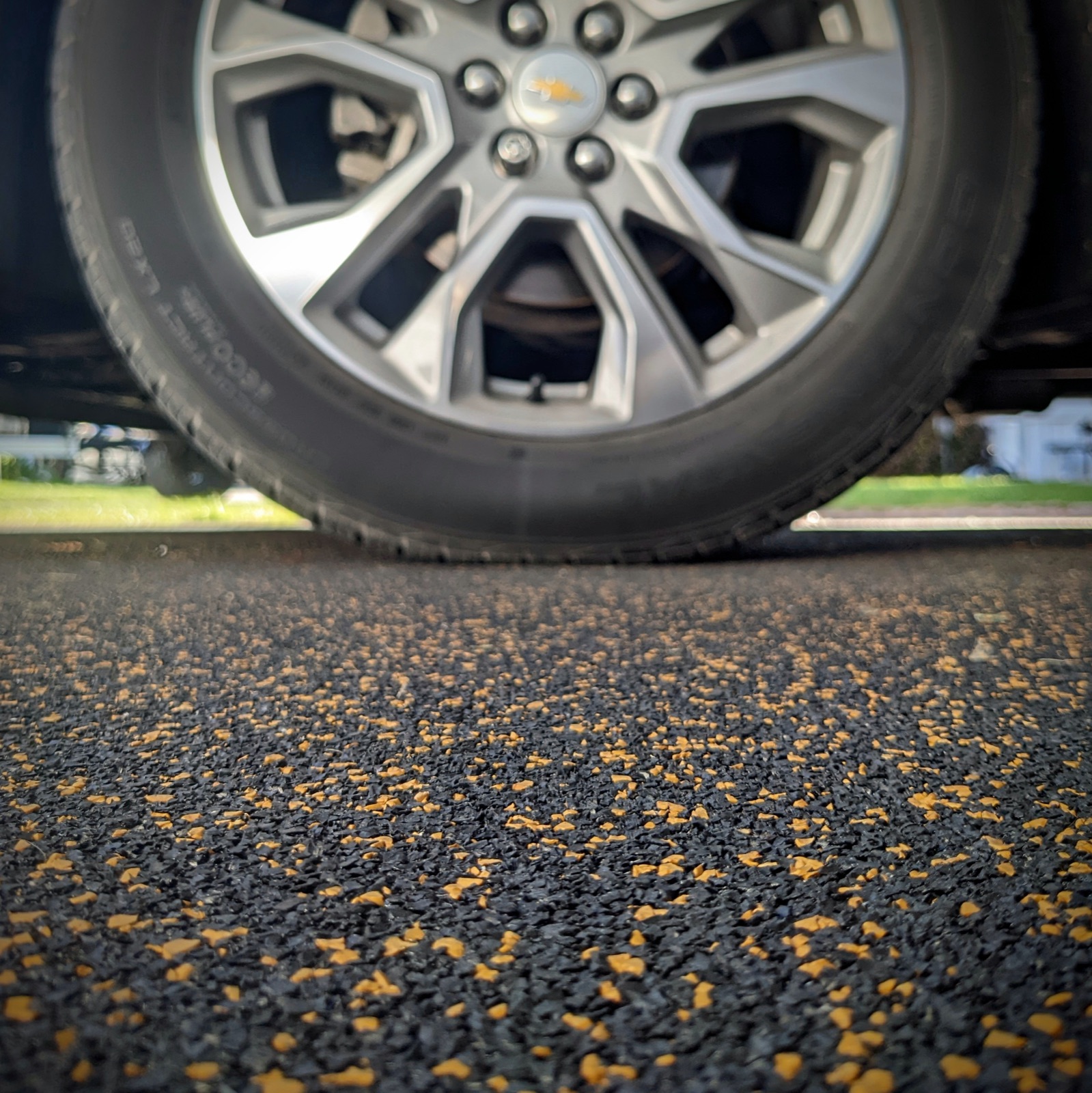 Close-up of rubber granules by a truck wheel