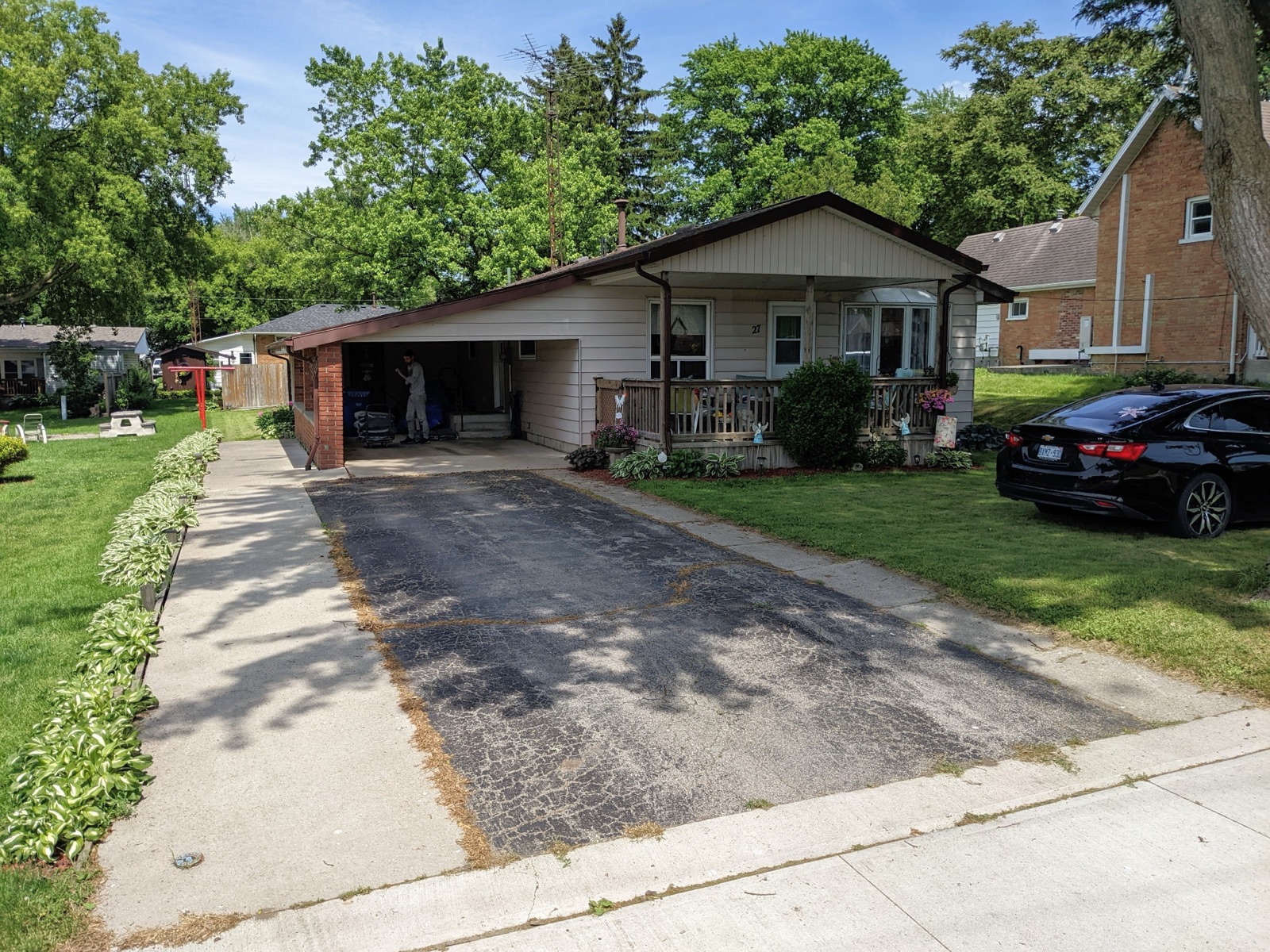 Worn asphalt driveway before resurfacing — before