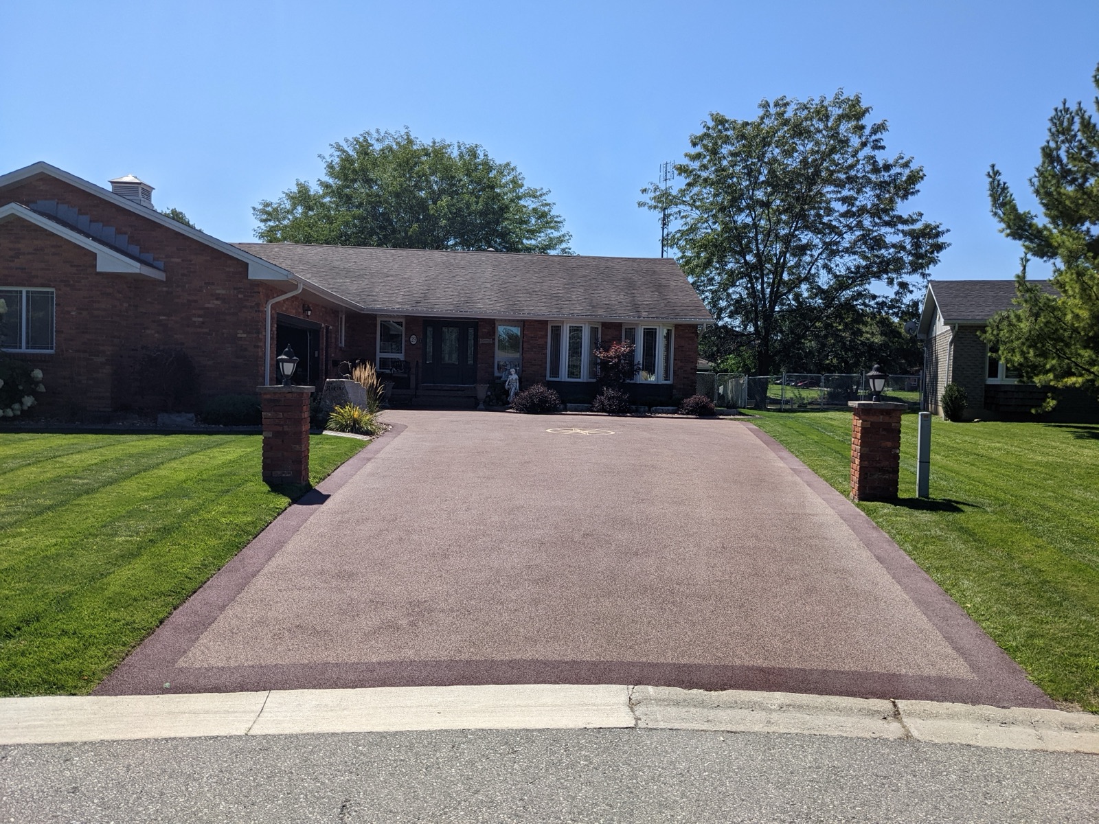 Burgundy resin driveway with brick ranch house — after