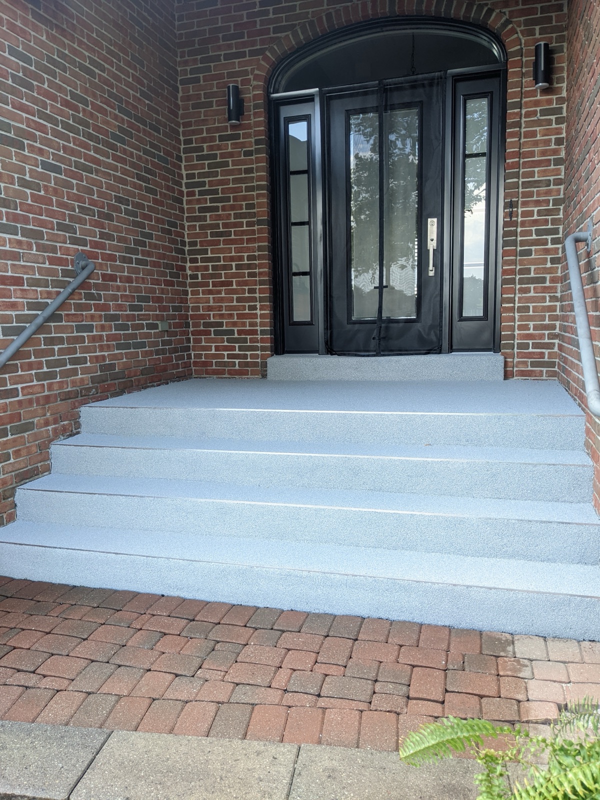 Arched double-door entry with grey resin — after