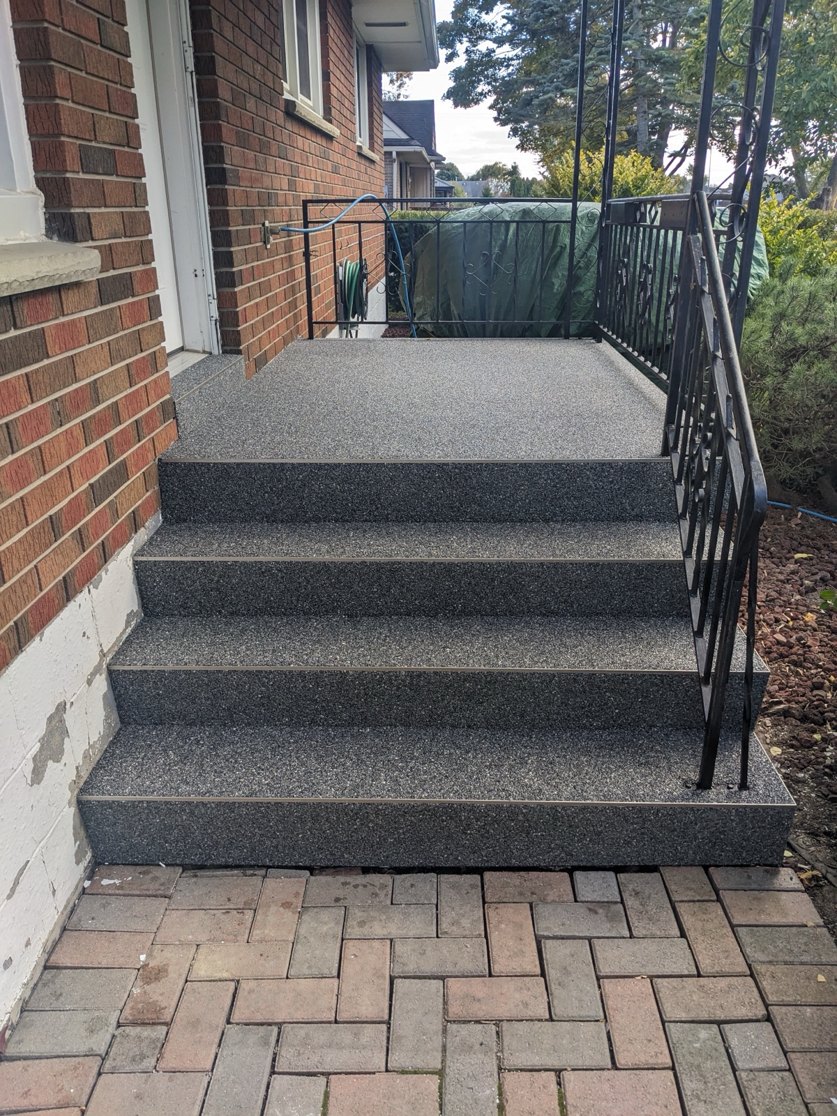 Dark grey resin steps landing on brick pavers — after