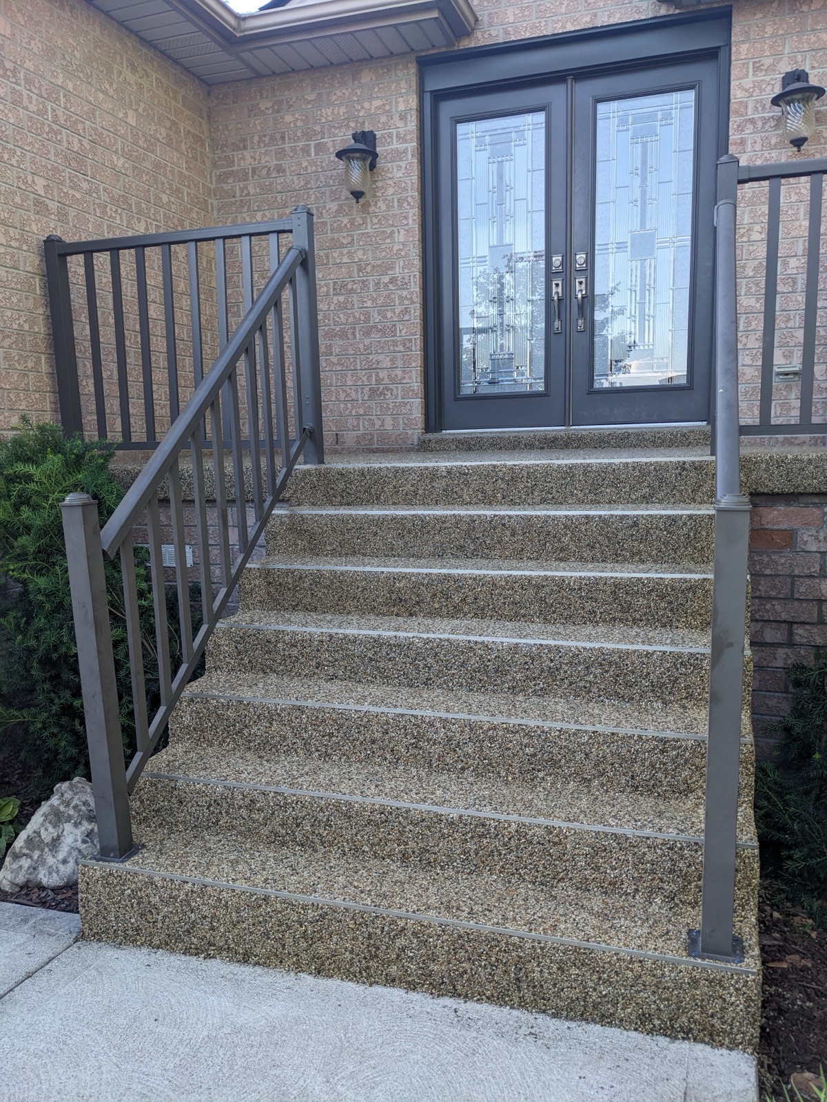Tan resin steps at a double-door entrance — after