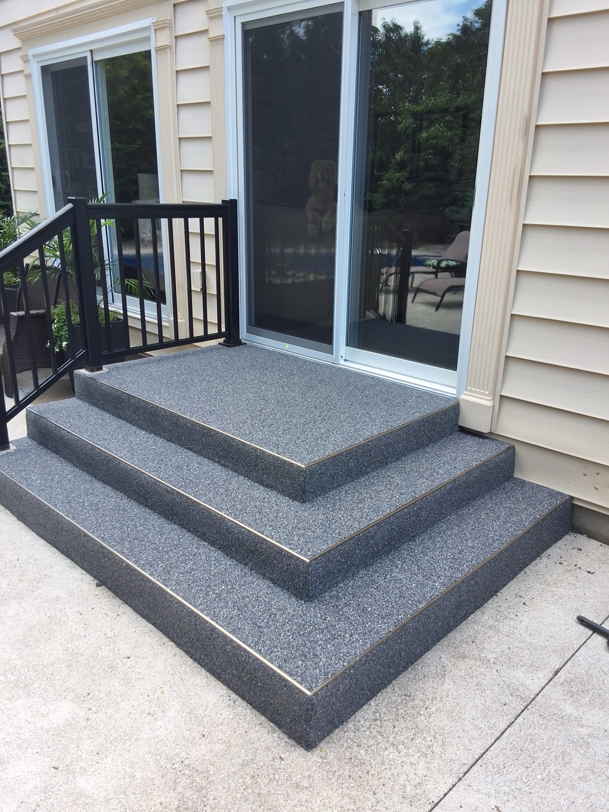 Front porch with dark grey resin steps and dog — after