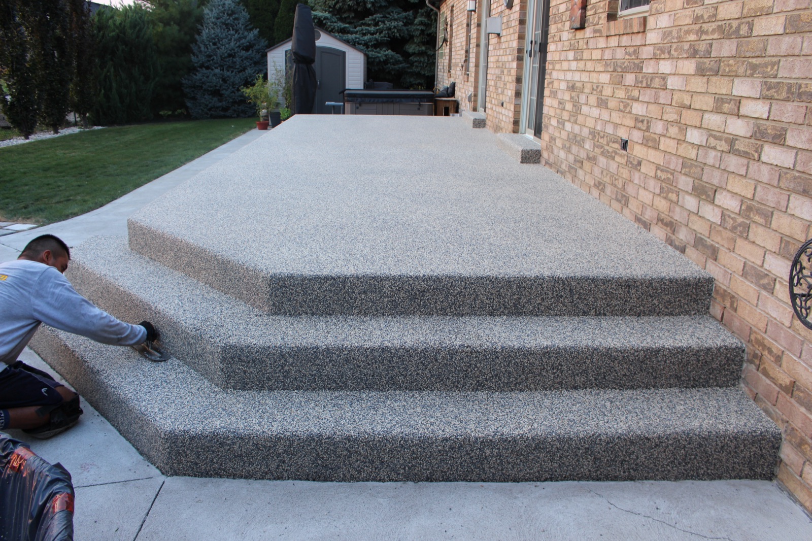 Installation crew troweling grey resin steps