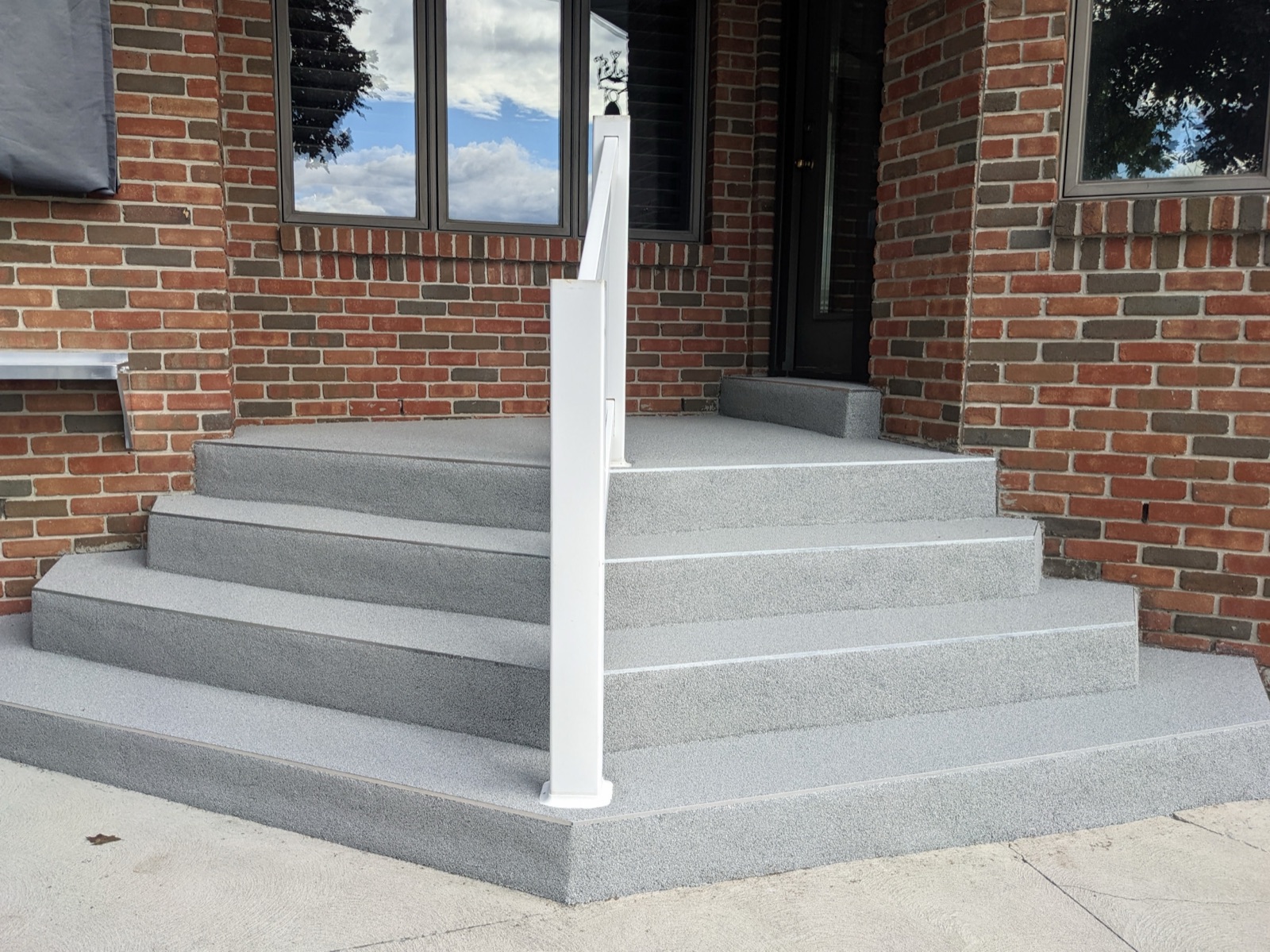 Grey resin patio with white posts — after