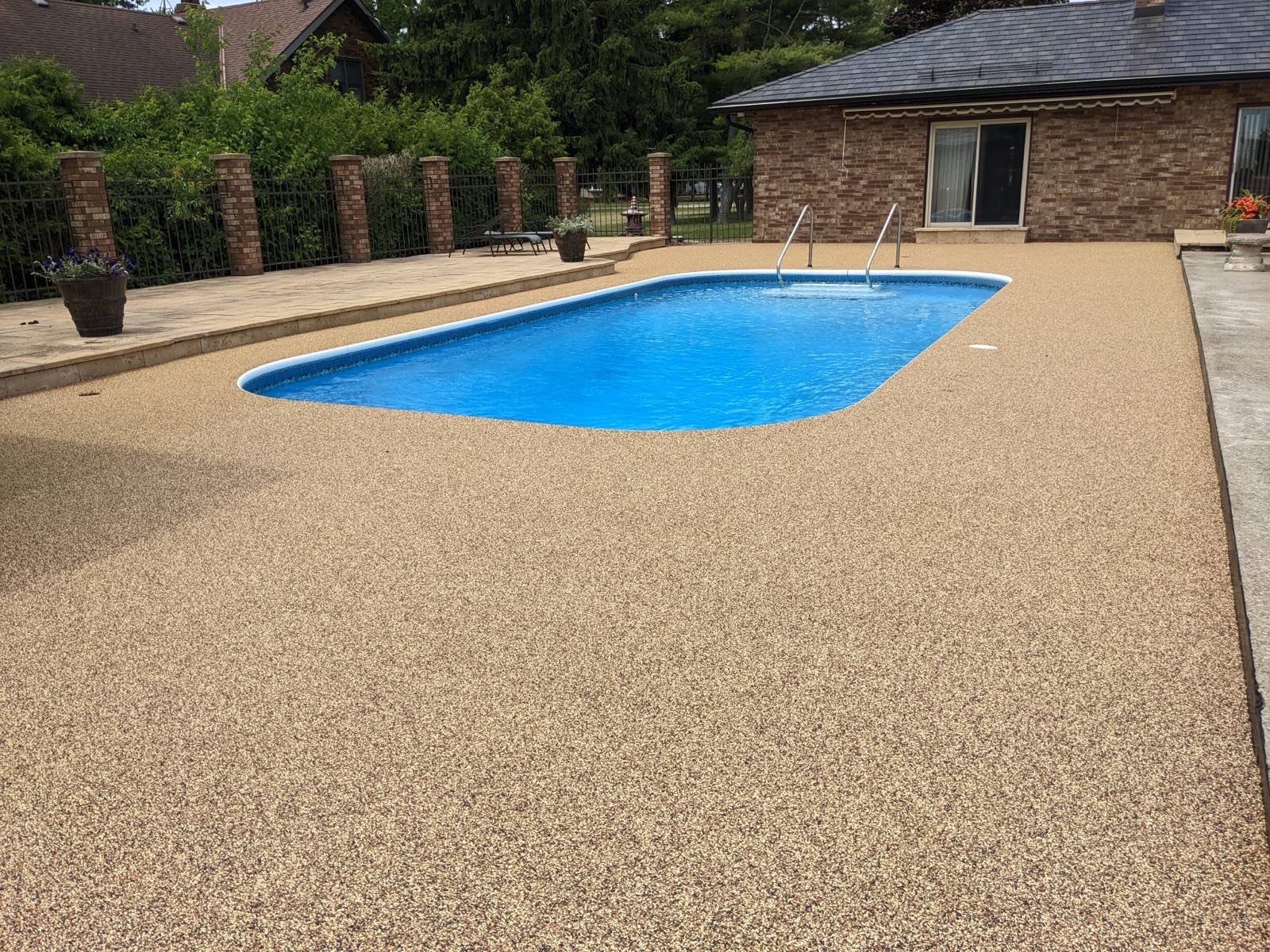 Tan pool deck with brick columns — after