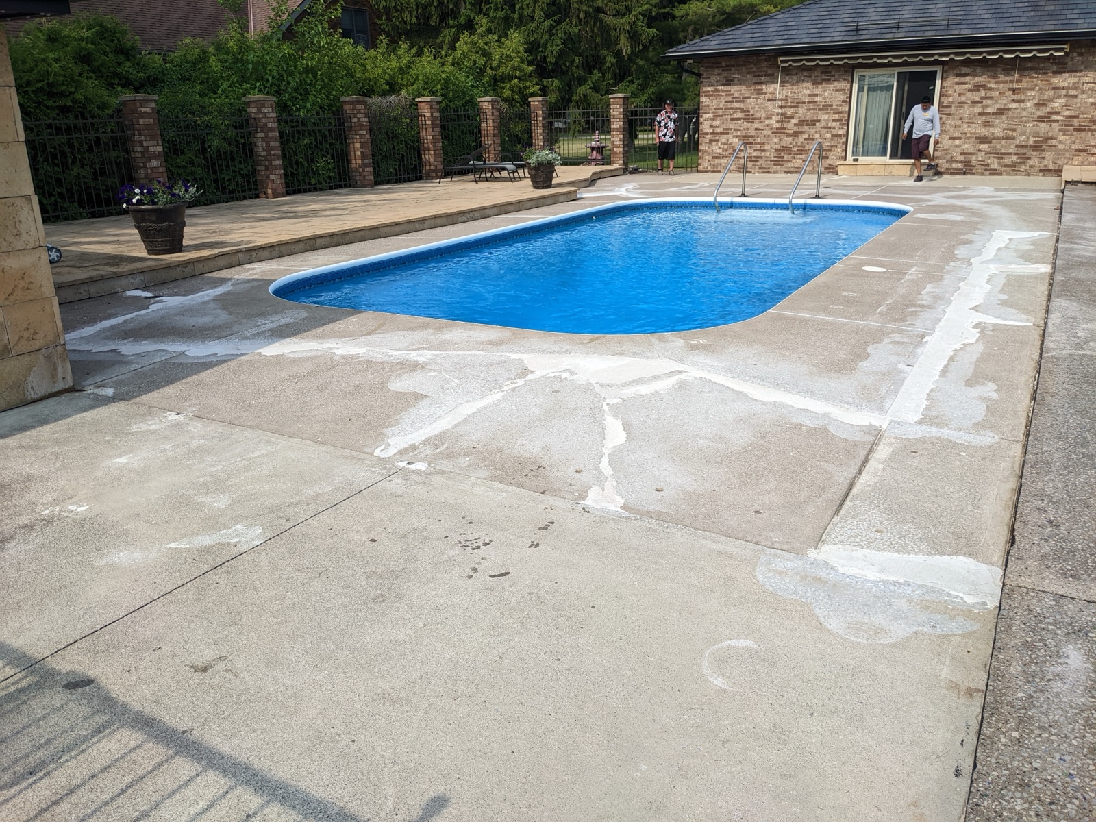 Pool deck before tan resin with brick columns — before