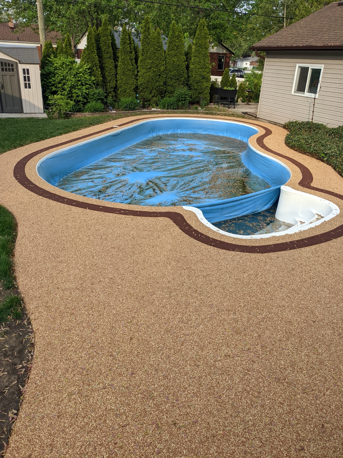 Tan resin pool deck around kidney-shaped pool — after