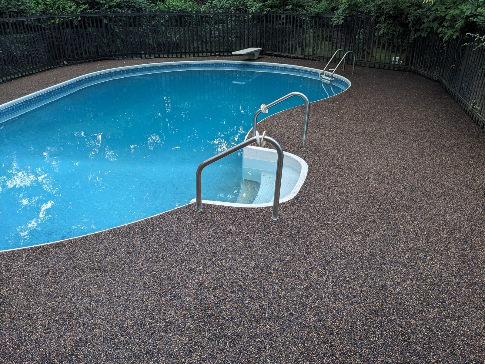 Brown resin deck around oval pool — after