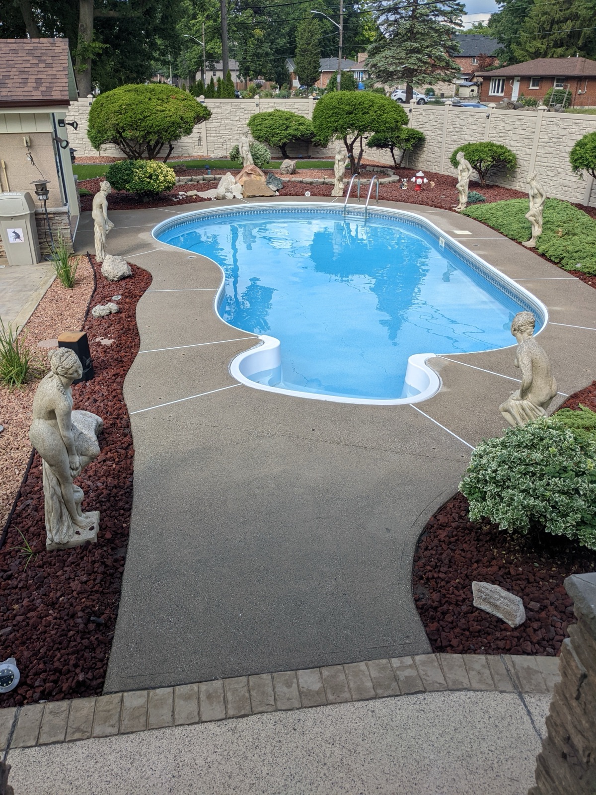 Tan resin pool deck with statues — after