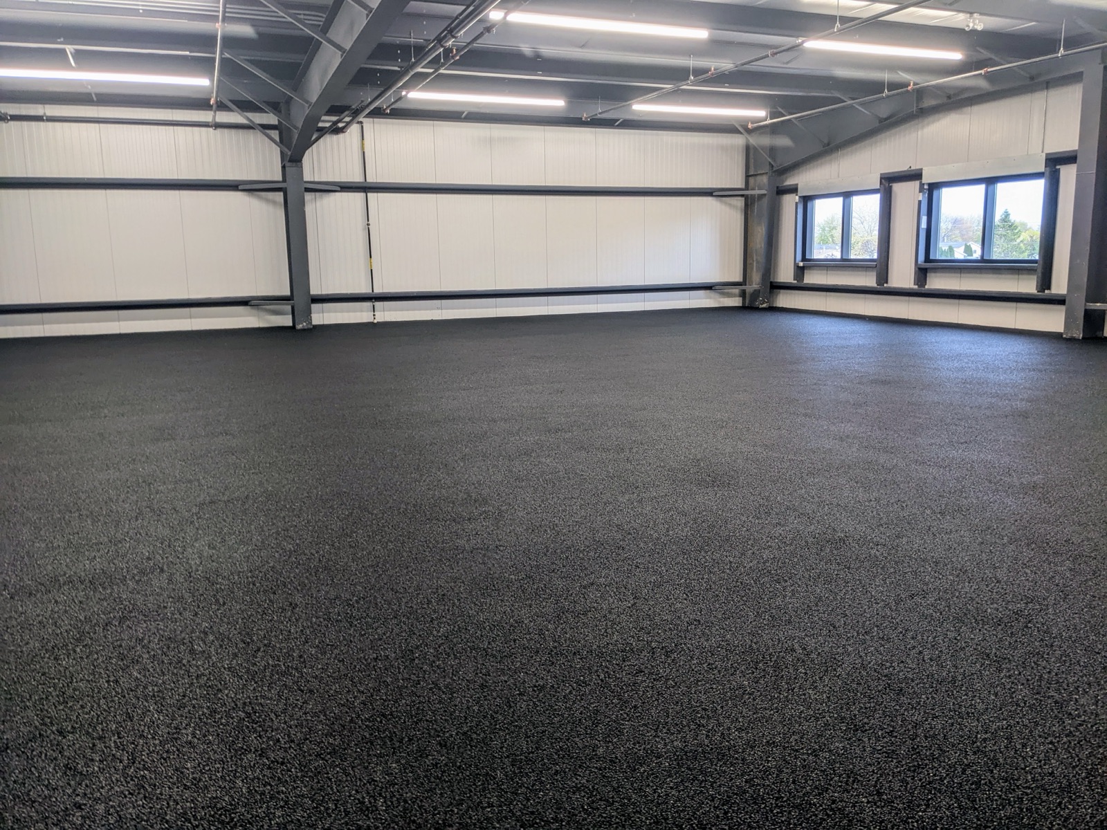 Black rubber surfacing in a commercial warehouse — after