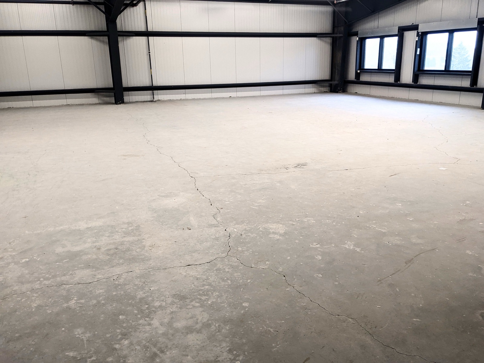 Cracked warehouse concrete floor before rubber coating — before